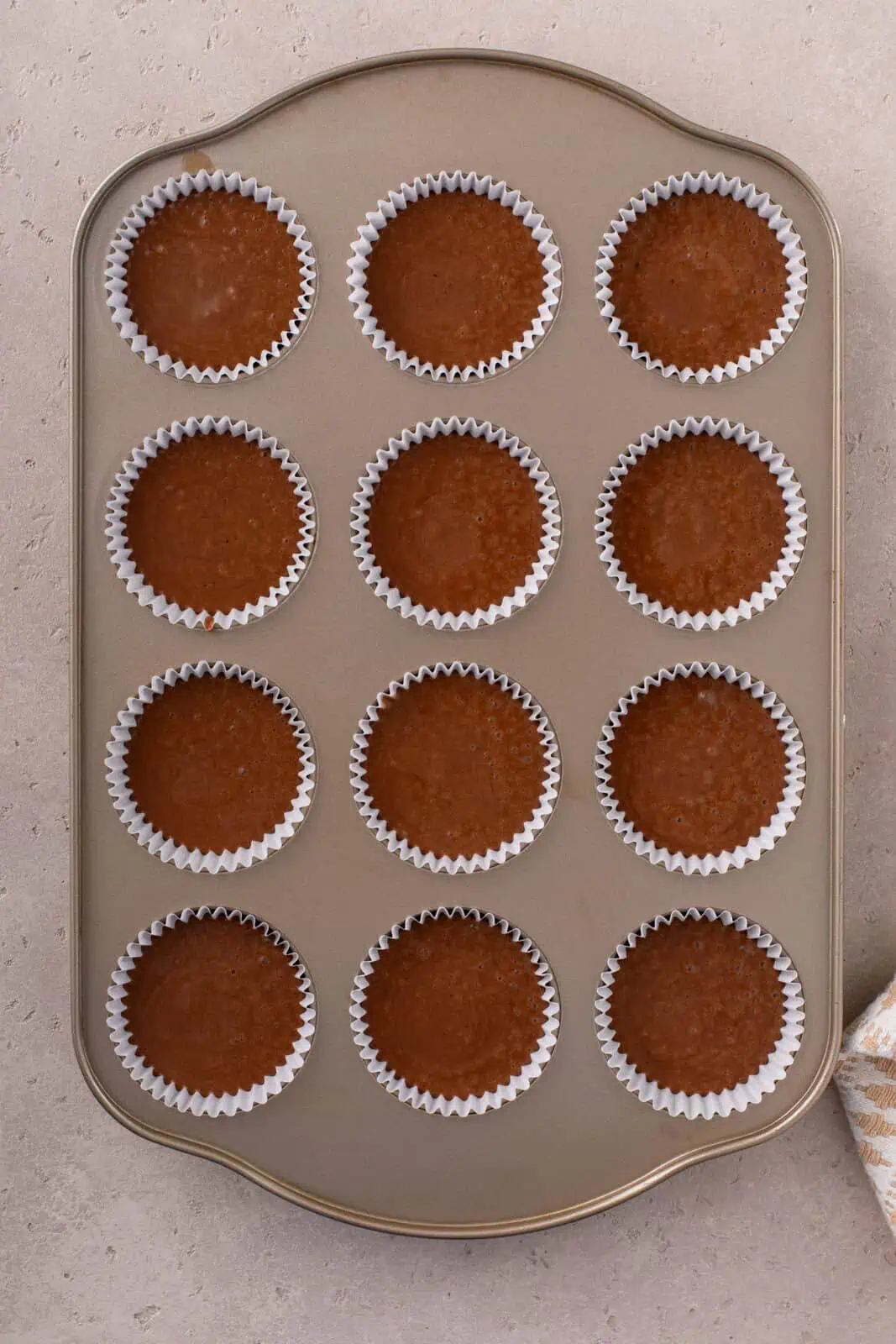 easy chocolate cupcake batter divided into lined muffin wells, ready to go in the oven.