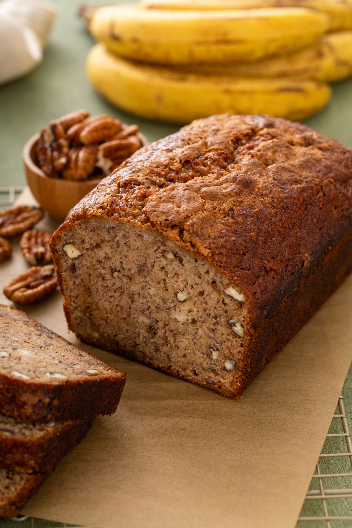 Sliced loaf of biquick banana bread on a piece of parchment paper.