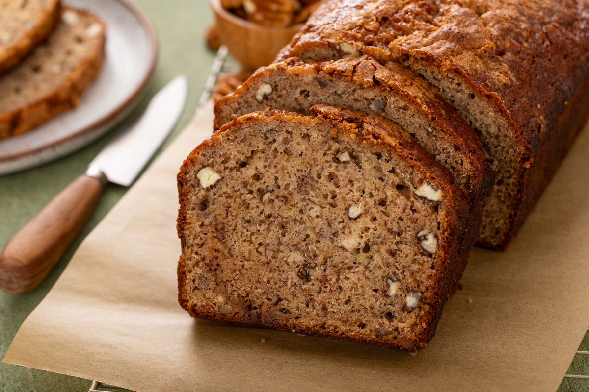 Slices of bisquick banana bread propped up on a piece of parchment paper.