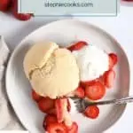 Overhead view of strawberry shortcake on a white plate, with a fork taking a bite of the cake, strawberries, and whipped cream. Text overlay includes recipe name.