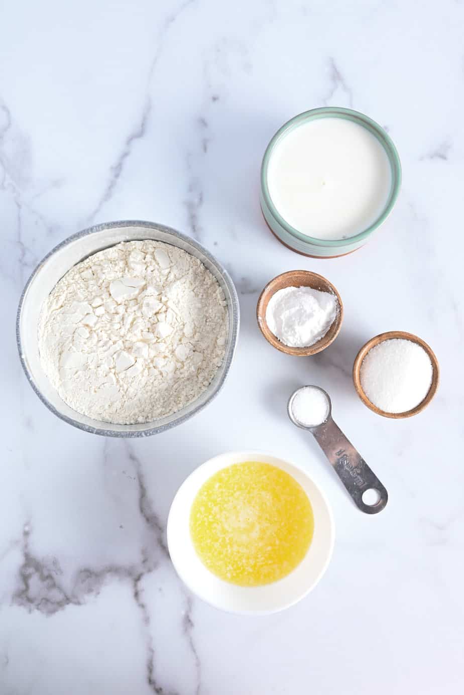 Ingredients for strawberry shortcake arranged on a marble countertop.