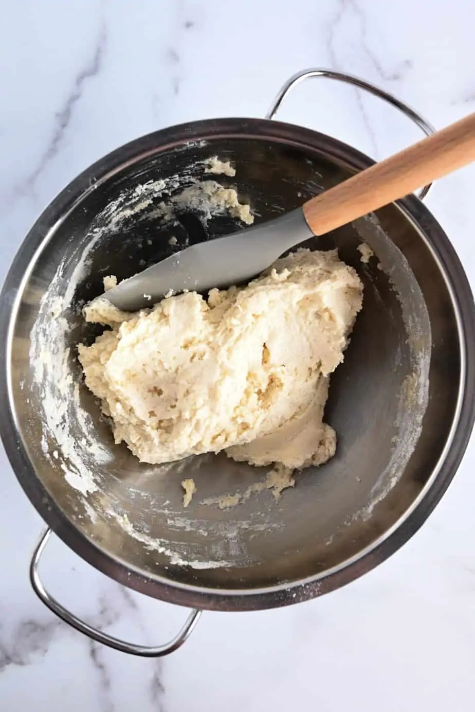 Dough for strawberry shortcakes being stirred in a metal bowl.