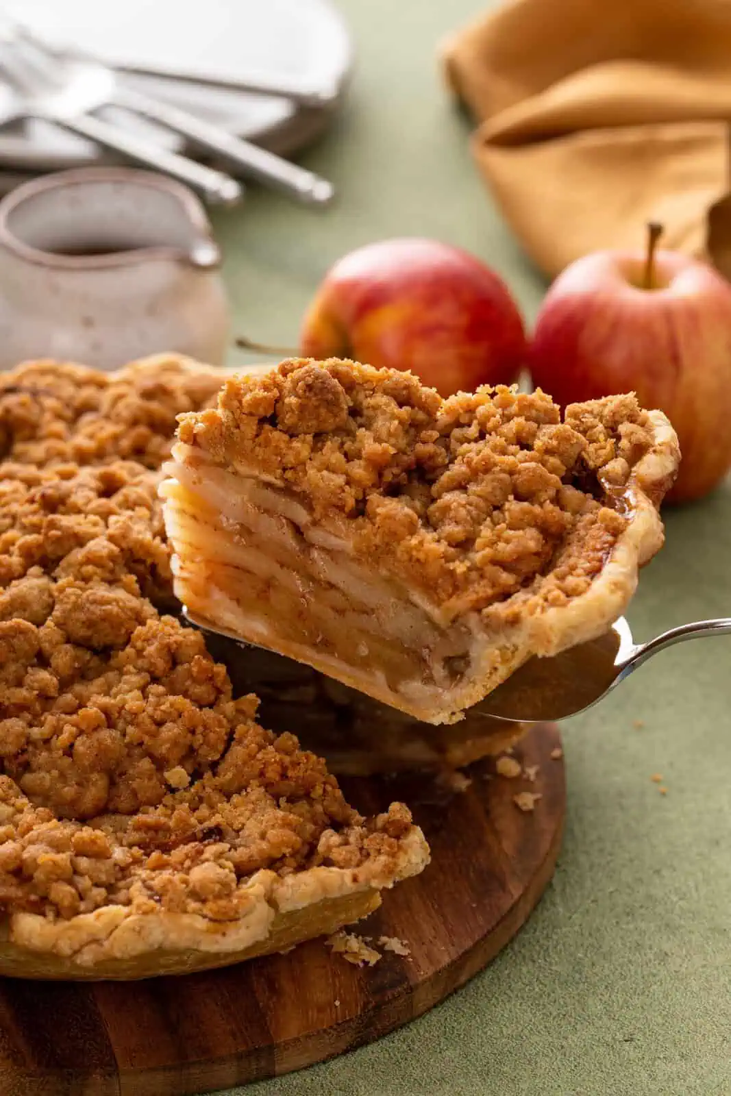 Pie server lifting up a slice of dutch apple pie.