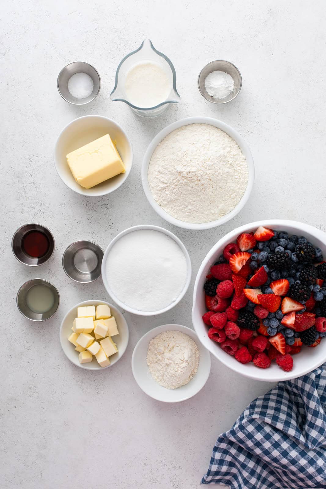Ingredients for berry cobbler arranged on a countertop.