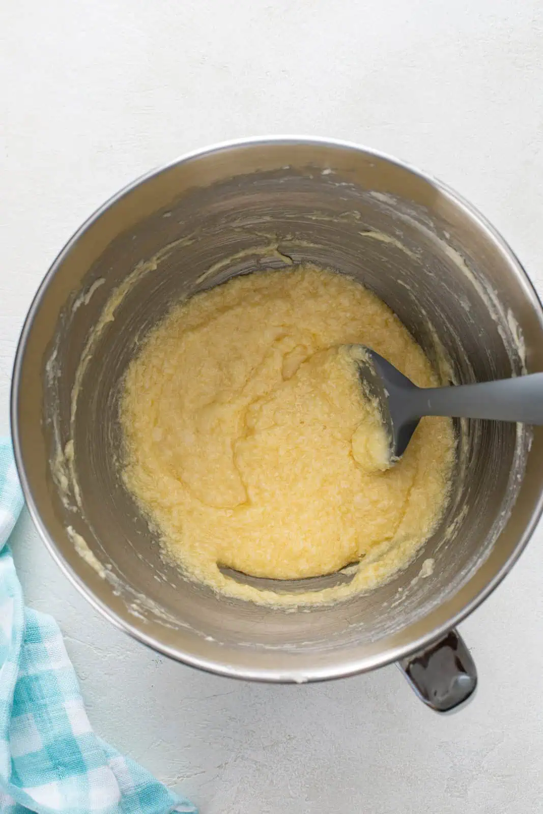 Eggs added to creamed butter and sugar in a metal bowl.