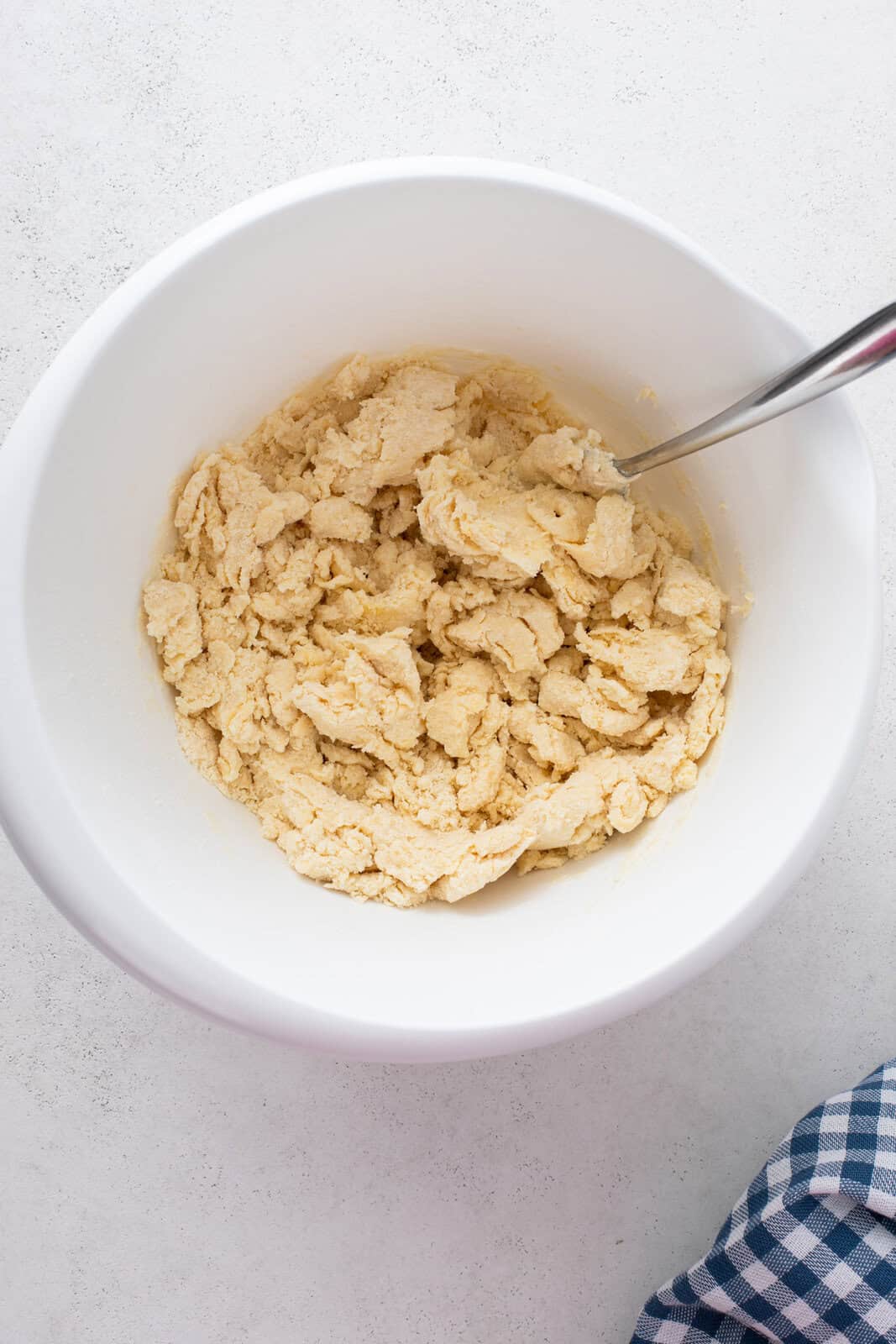 Shaggy dough for berry cobbler pastry in a white bowl.