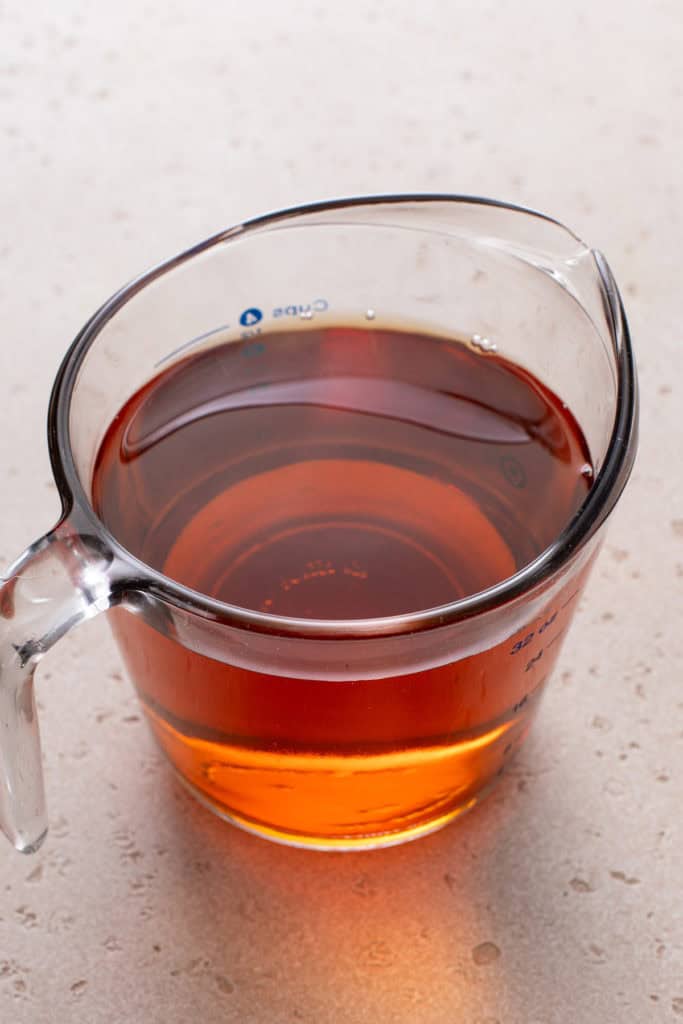 Sweet tea mixture in a glass measuring cup.