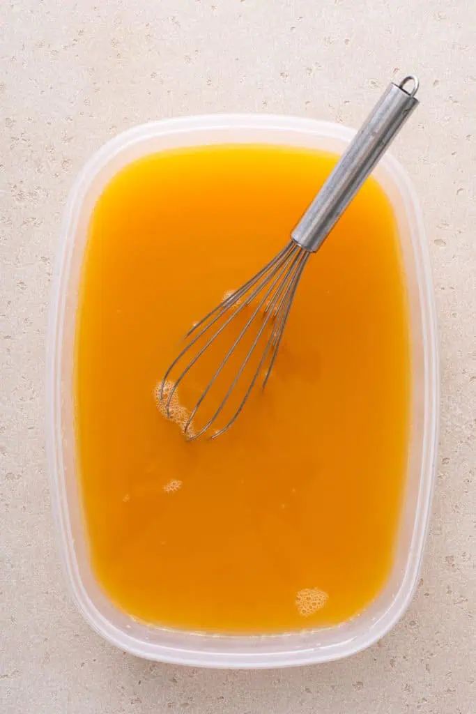 Whisk mixing bourbon slush mixture in a container.