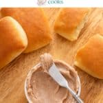 Dinner rolls surrounding a bowl of cinnamon honey butter and butter knife on a wooden board. Text overlay includes recipe name.