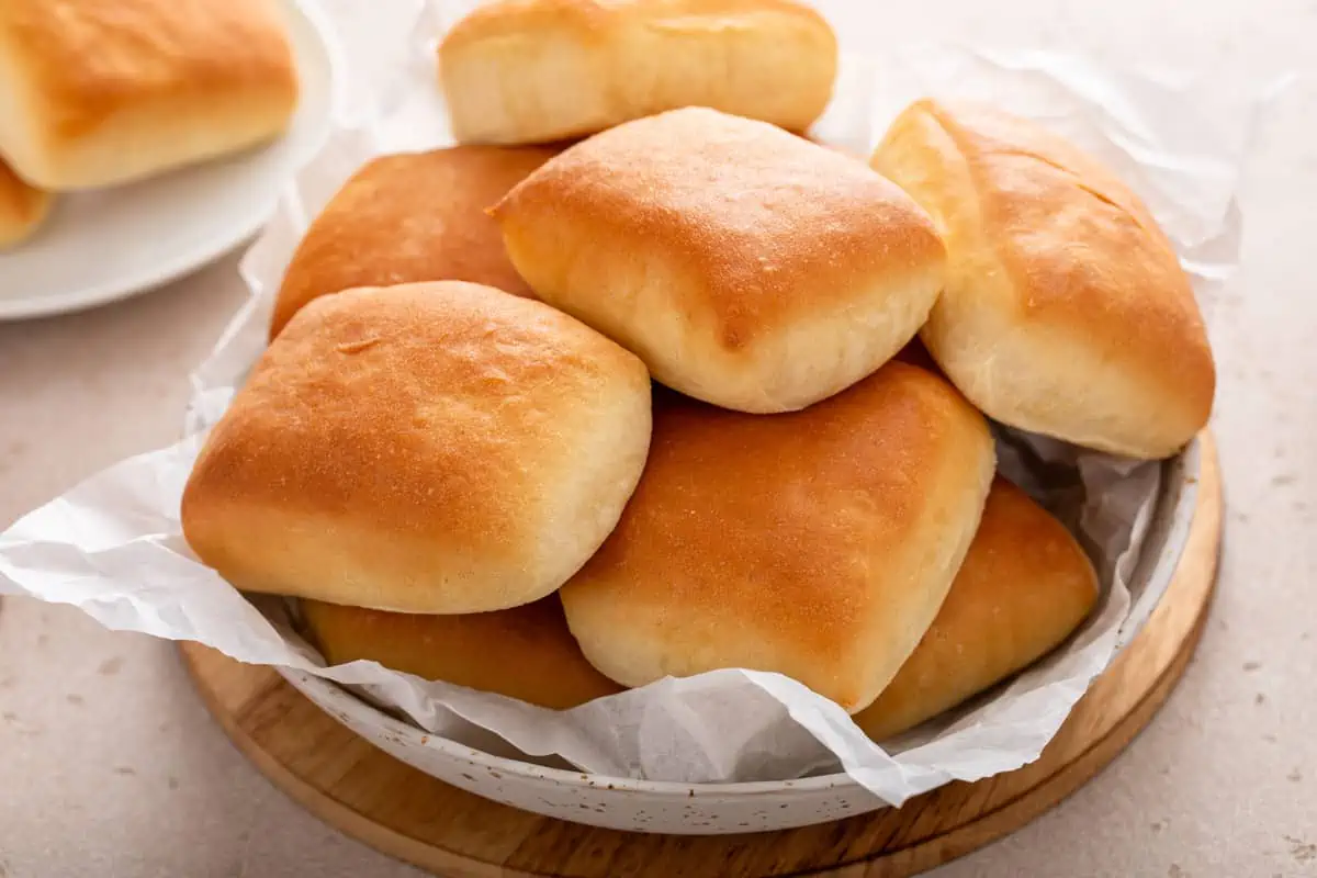Texas roadhouse rolls piled into a parchment-lined basket.