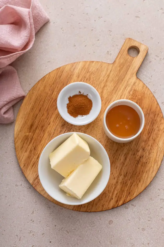 Ingredients for cinnamon honey butter arranged on a wooden board.