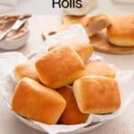 Close up of texas roadhouse rolls arranged in a bread basket on a beige countertop. Text overlay includes recipe name.