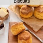 Two sweet potato biscuits on a wooden board with more biscuits in the background. Text overlay includes recipe name.