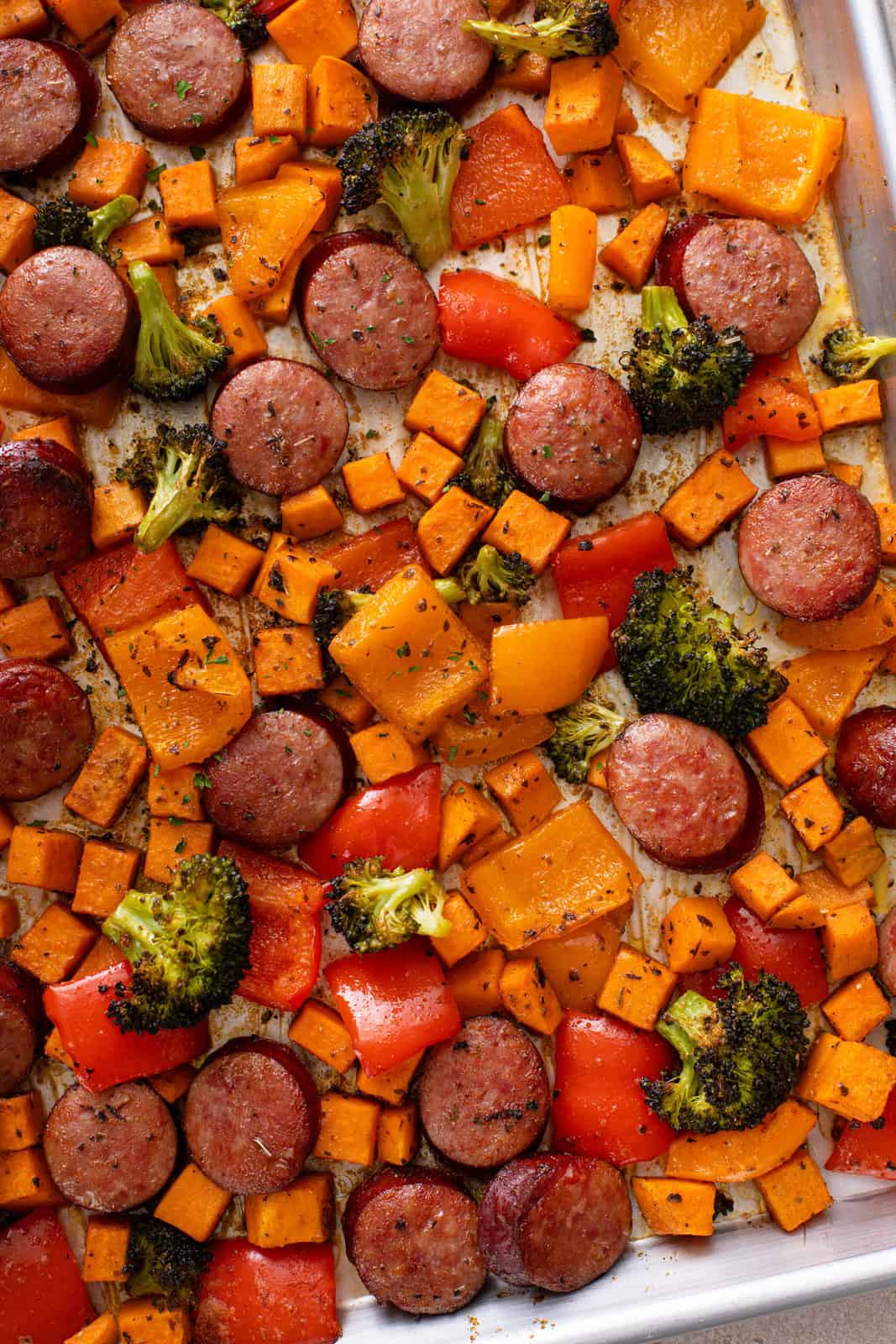 Sheet pan filled with roasted sausage and veggies.