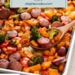 Wooden spoon filled with sausage and veggies on a sheet pan. Text overlay includes recipe name.