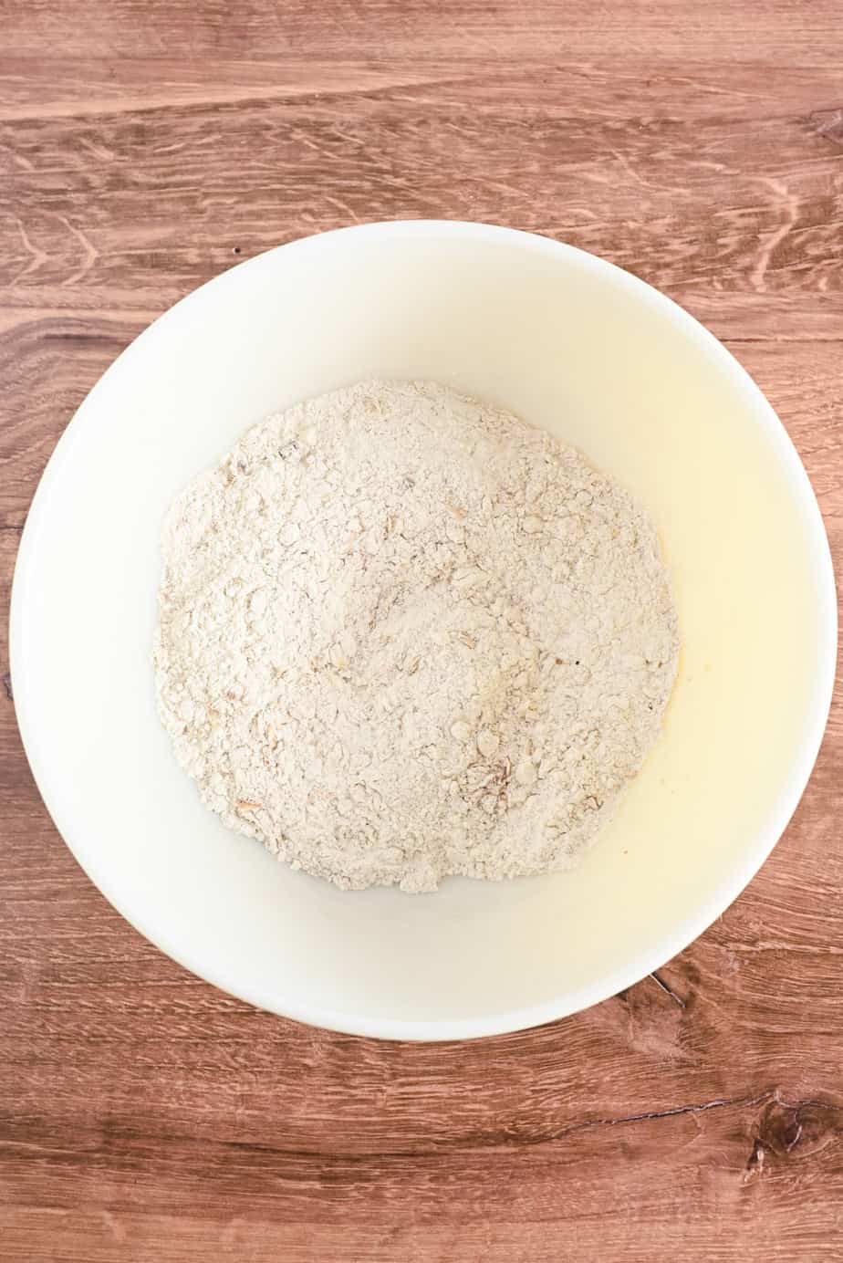 Dry ingredients for applesauce bread in a ceramic mixing bowl.