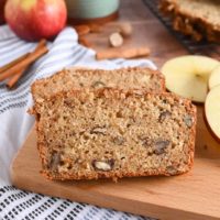 Two slices of applesauce bread on a wooden board.