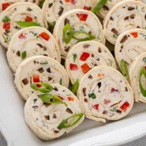 Close up of sliced cream cheese ranch roll ups on a white platter.
