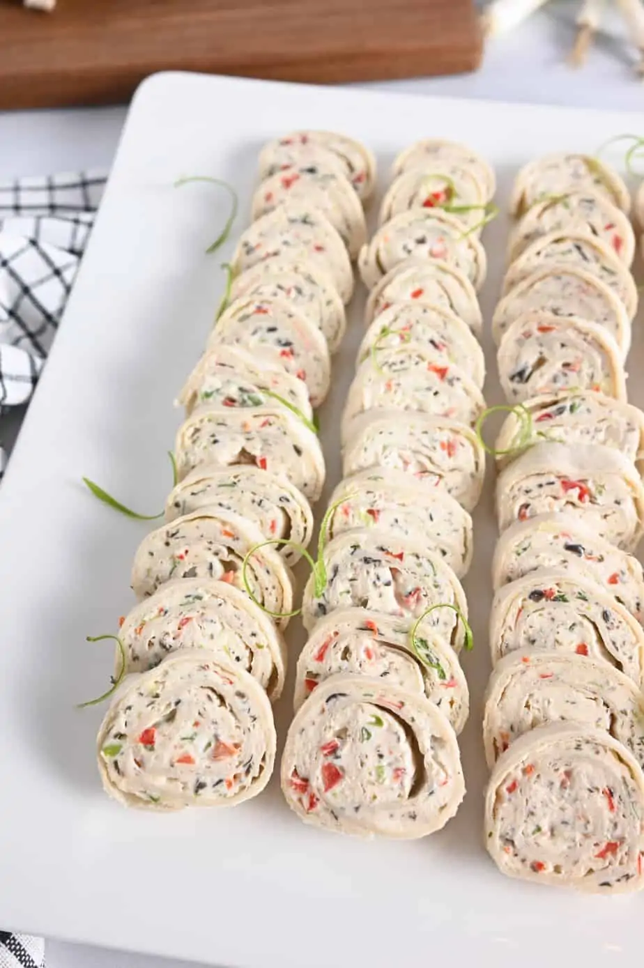 Rows of cream cheese ranch rollups on a white platter.