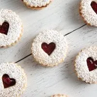 Raspberry Linzer Cookies sandwich bright and tangy raspberry jam between two almond cookies. They’re as delicious as they are beautiful!