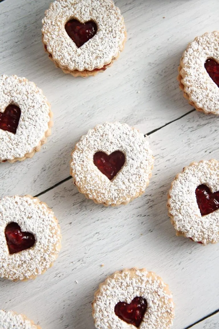 Raspberry Linzer Cookies sandwich bright and tangy raspberry jam between two almond cookies. They’re as delicious as they are beautiful!