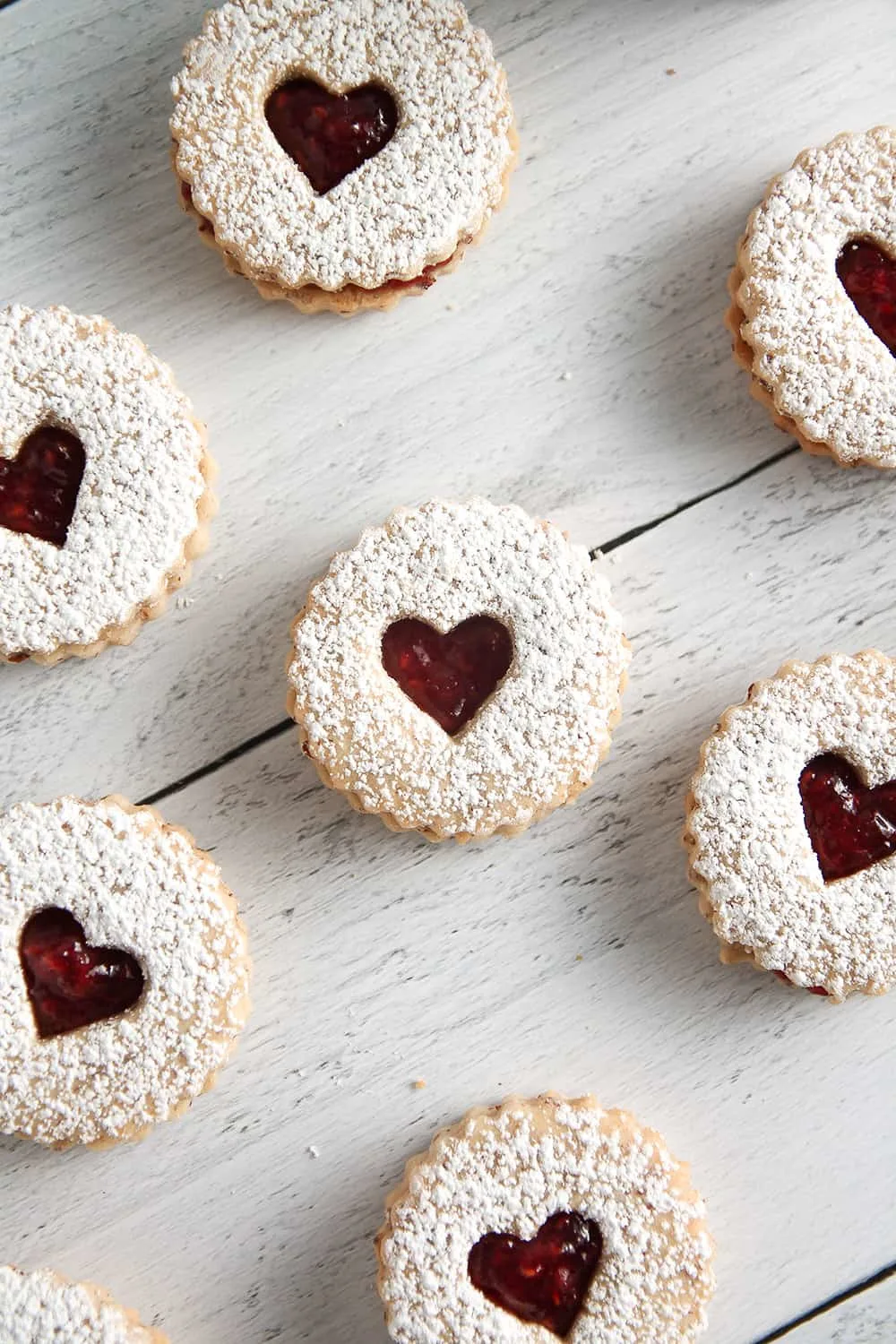 Raspberry Linzer Cookies sandwich bright and tangy raspberry jam between two almond cookies. They’re as delicious as they are beautiful! 