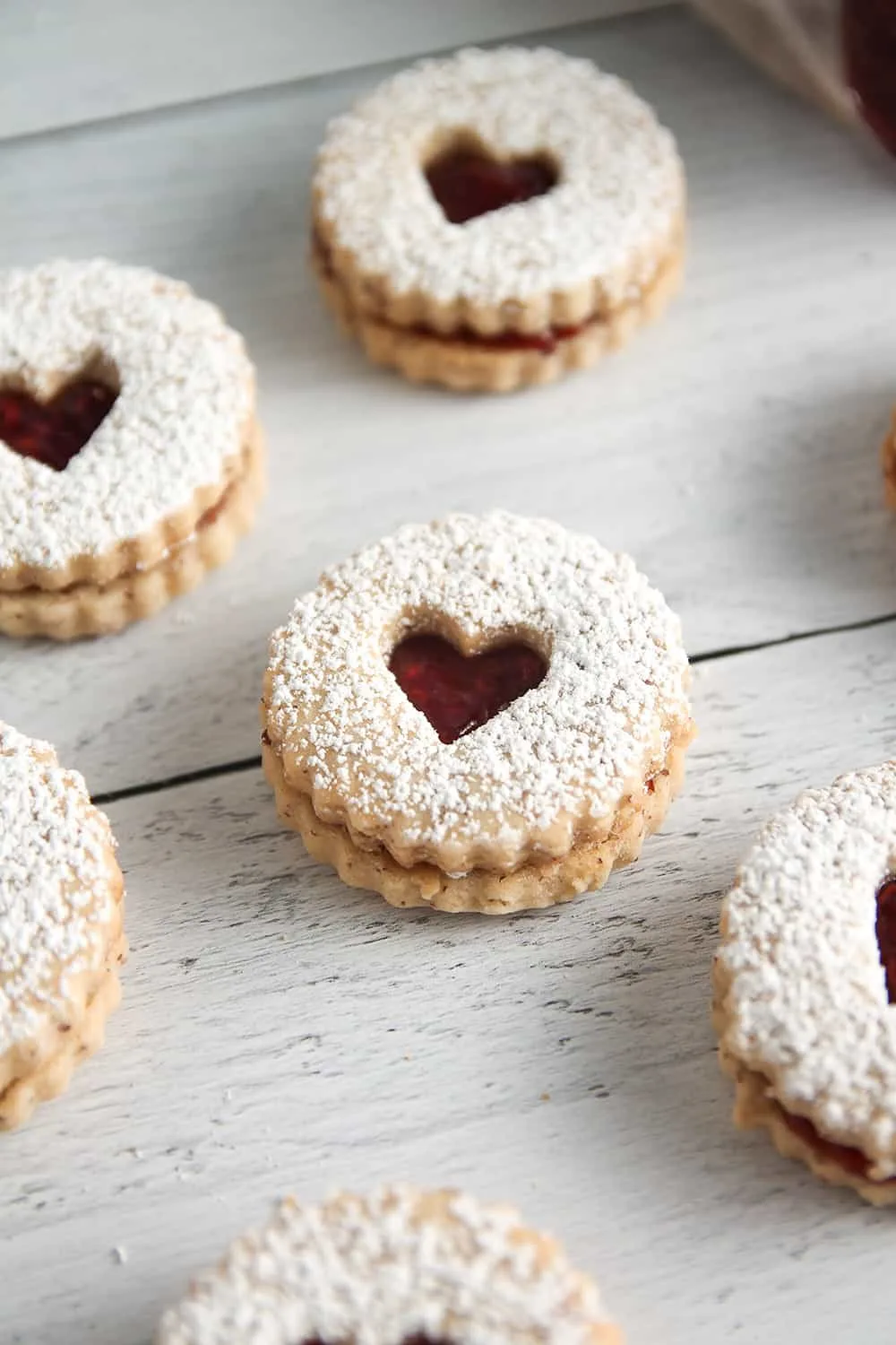 Raspberry jam gets sandwiched between two almond cookies to make traditional Raspberry Linzer Cookies.