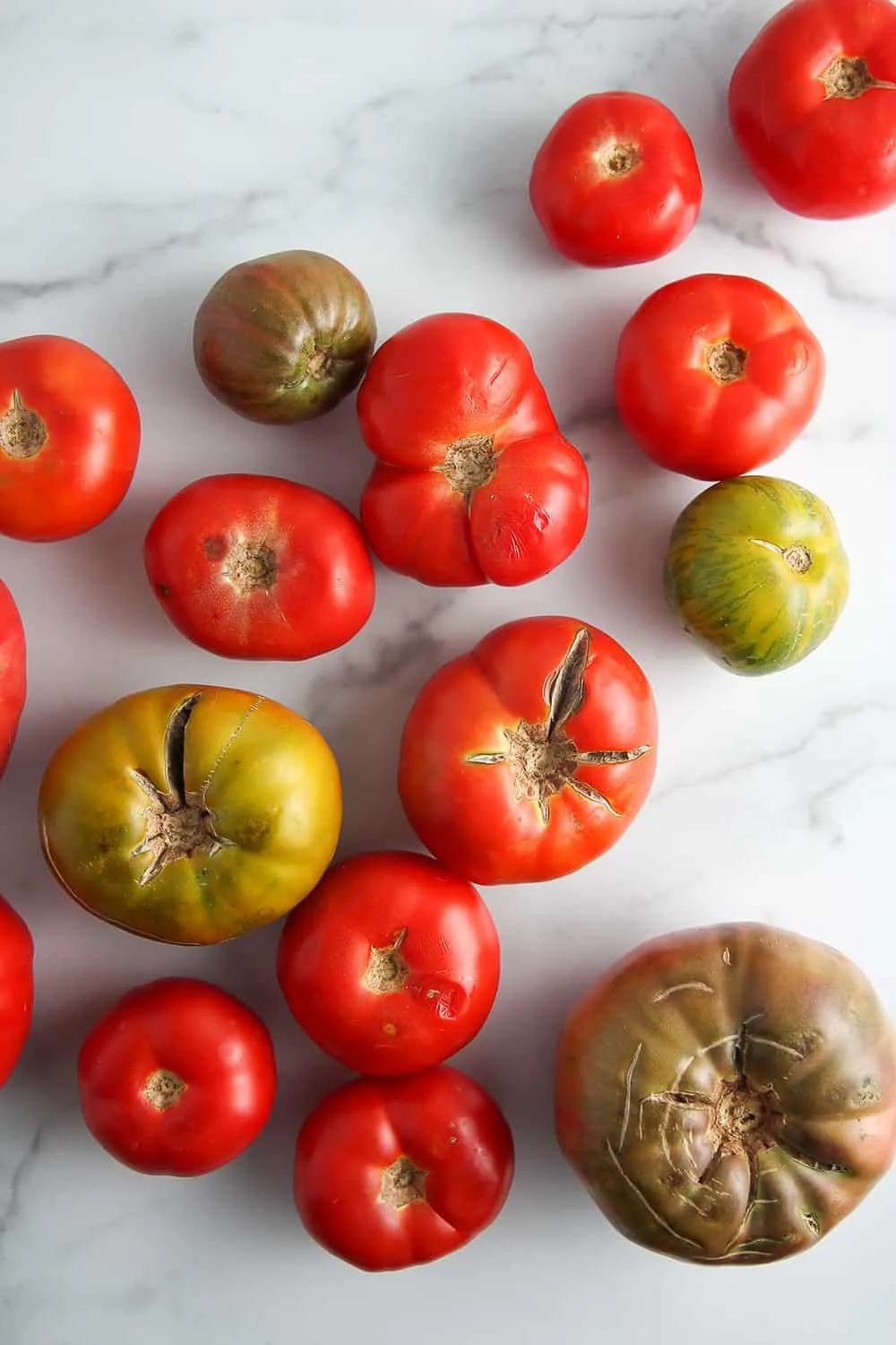 Assorted fresh heirloom tomatoes on a marble surface