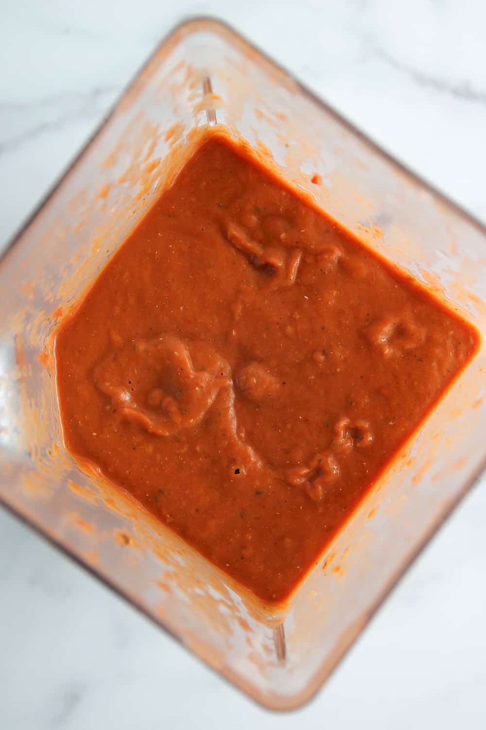 Overhead view of freshly blended roasted tomato sauce in a blender