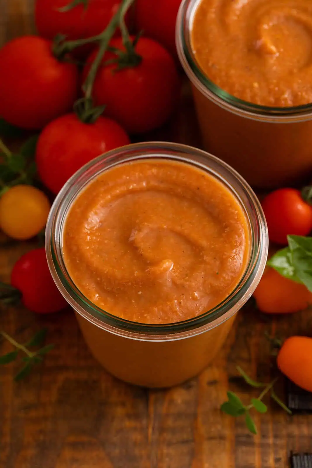 Overhead view of roasted tomato sauce in a glass jar.