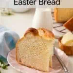 Two slices of paska set upright on a pink plate with a small jug of milk in the background. Text overlay includes recipe name.