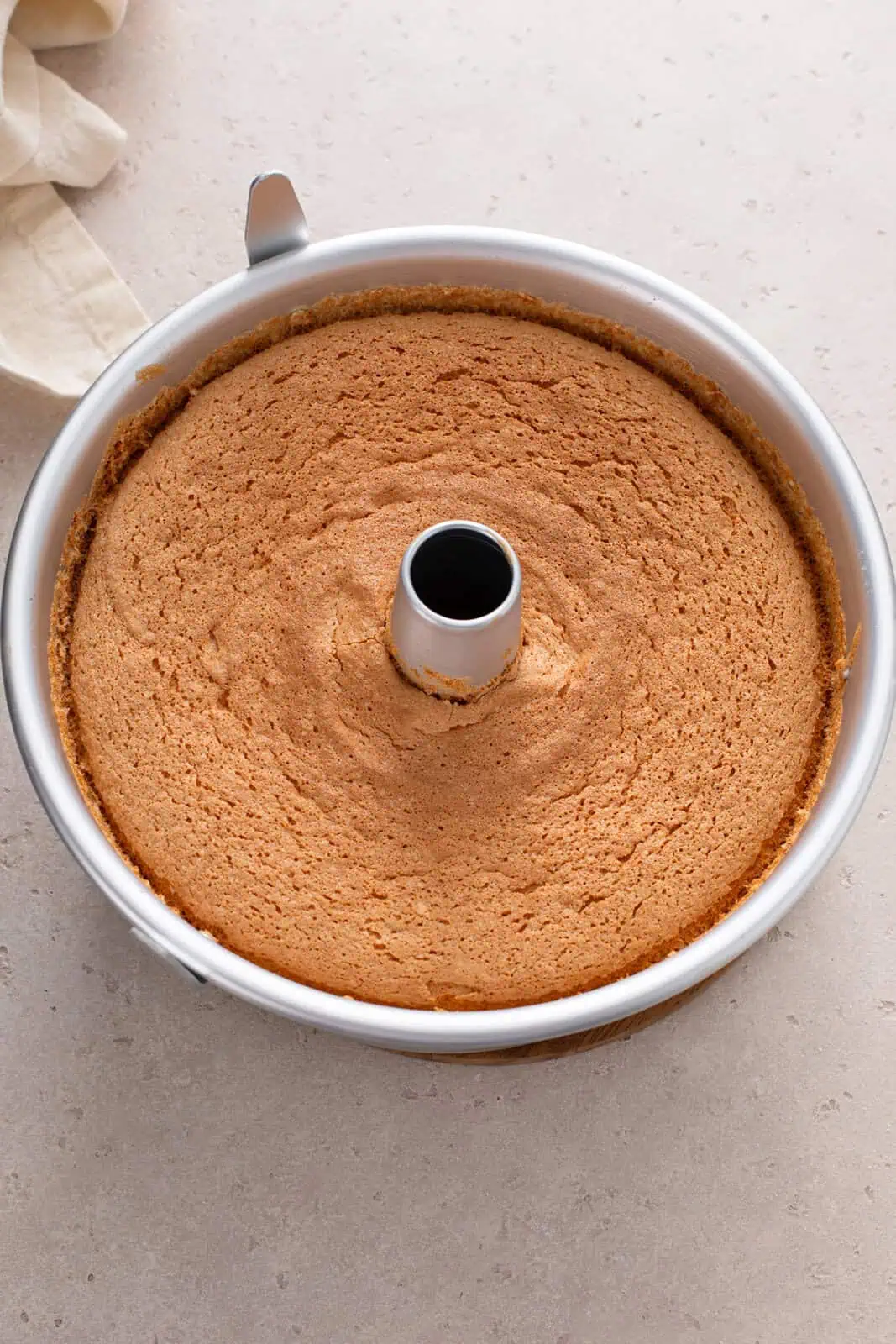 Baked angel food cake in an aluminum pan.