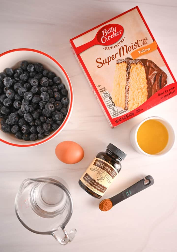 Ingredients for blueberry crumb cake arranged on a white countertop