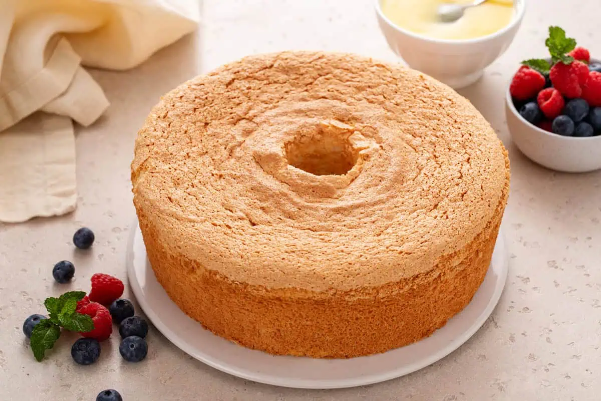 Cooled angel food cake removed from the pan and set on a cake plate.
