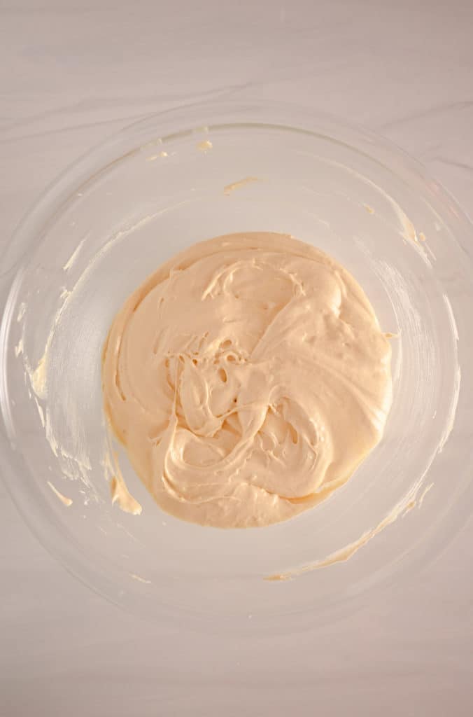Cake batter for blueberry crumb cake in a glass mixing bowl