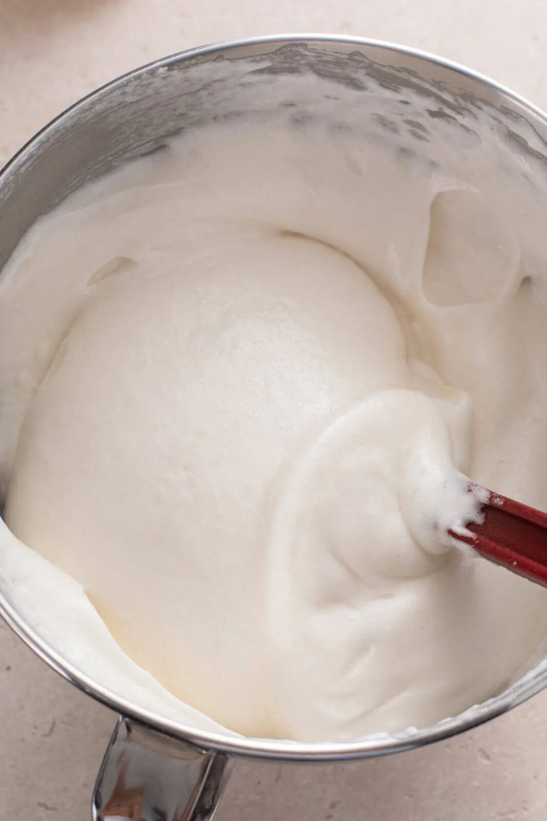 Dry ingredients being folded into egg white mixture for angel food cake.