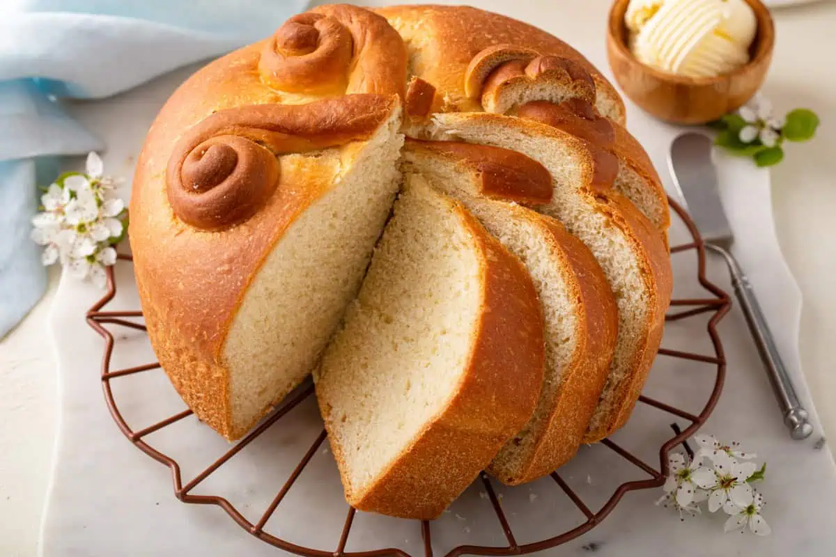 Close up of a round loaf of paska with several slices cut from it.