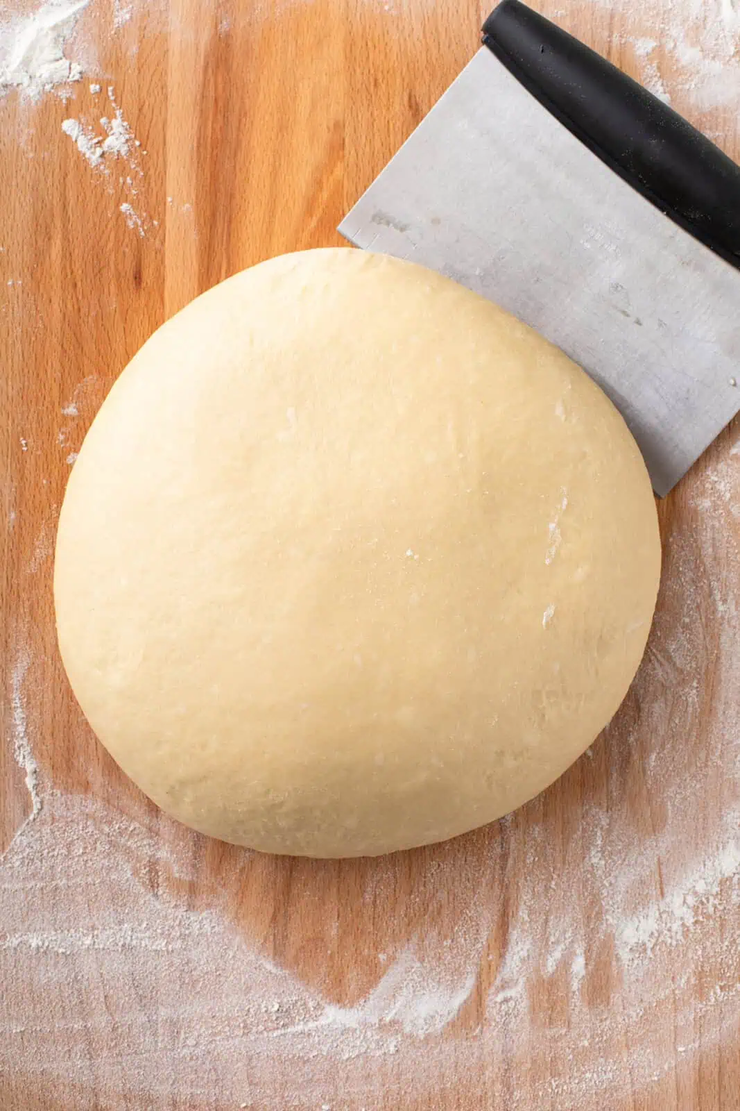 Paska dough kneaded into a smooth ball on a lightly floured work surface.