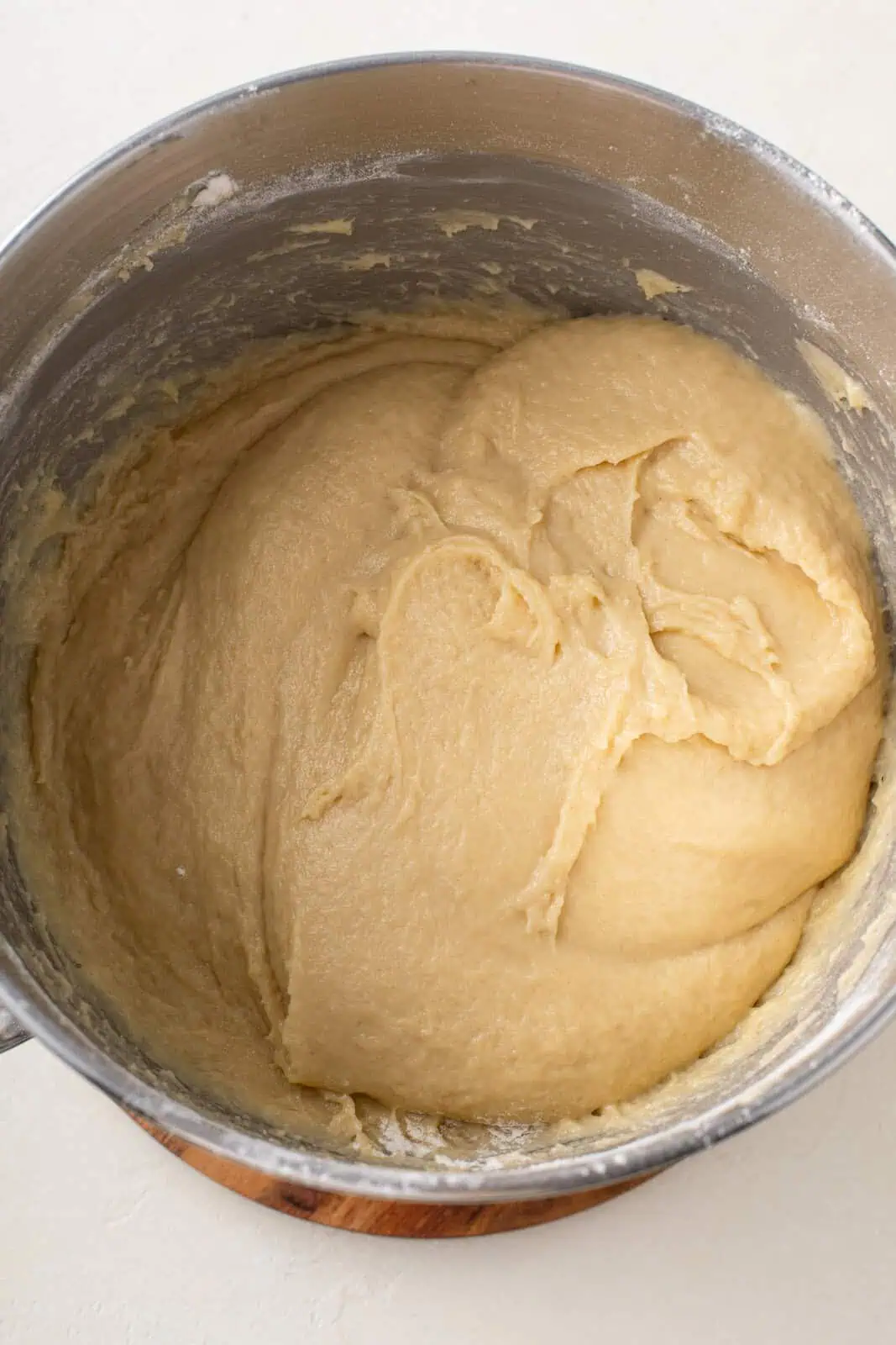 Paska dough mixed in the bowl of a stand mixer. The dough is sticky and somewhat loose.