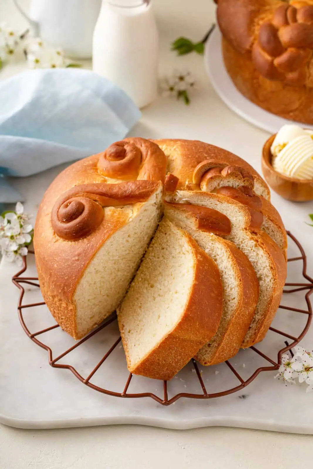 Several slices cut from a round loaf of paska on a wire rack.