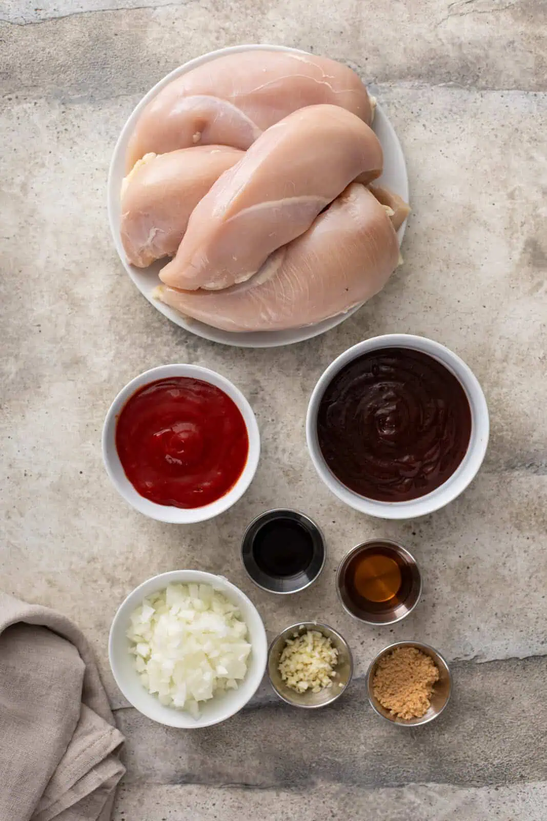 Ingredients for slow cooker pulled chicken arranged on a countertop.