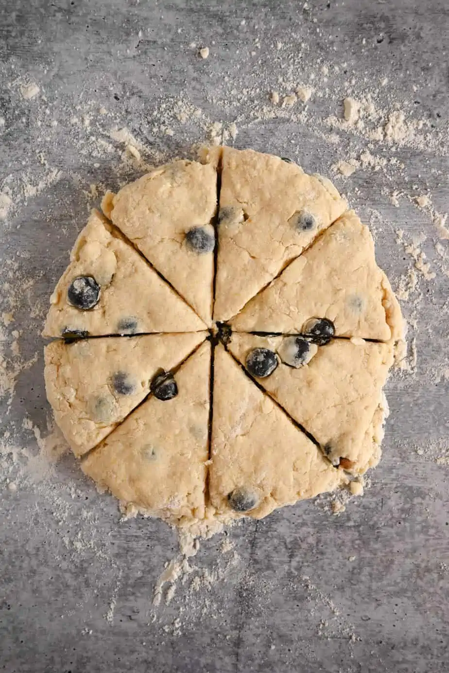 Blueberry scone dough in a circle and cut into 8 triangles.