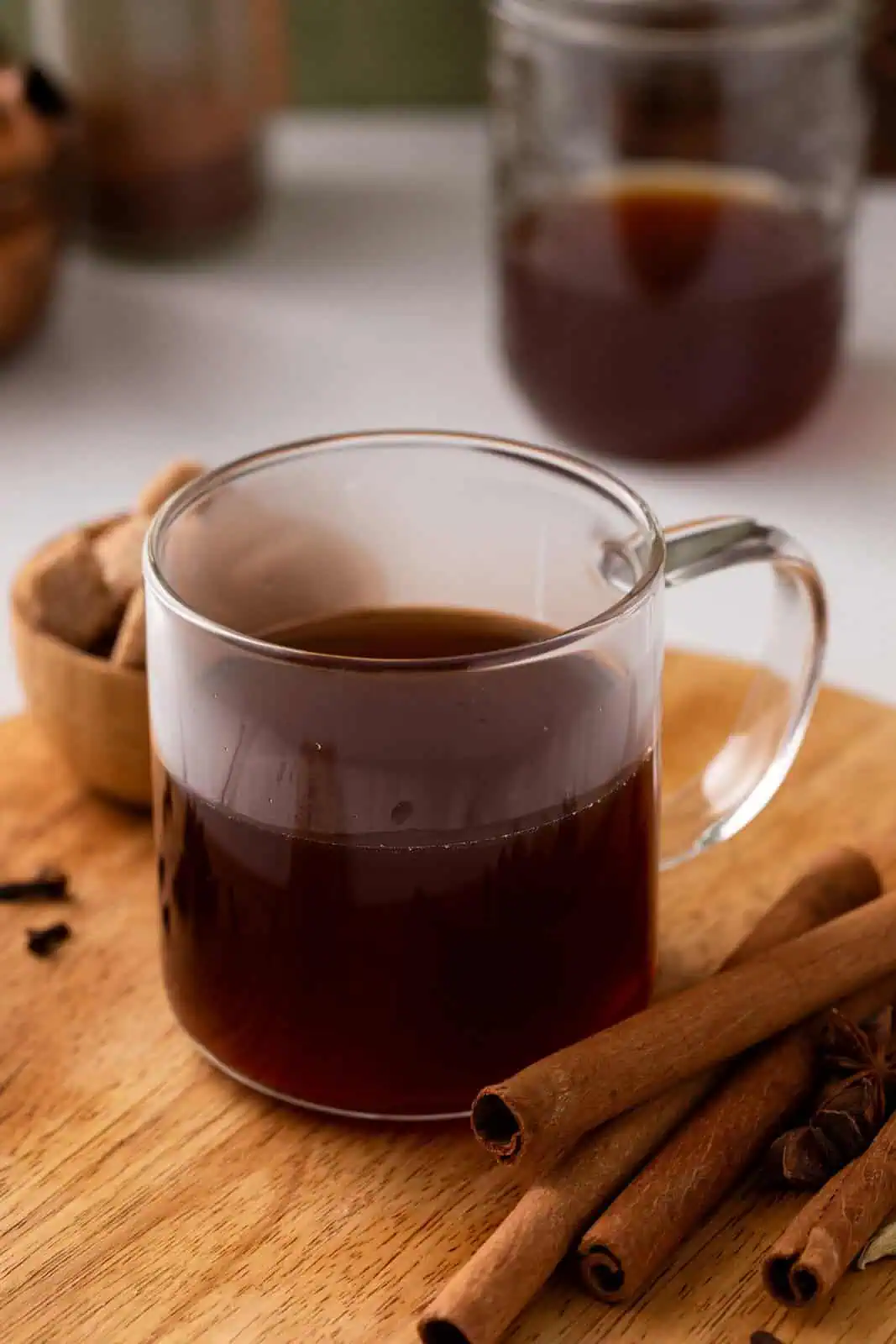 Glass mug halfway filled with hot chai concentrate.