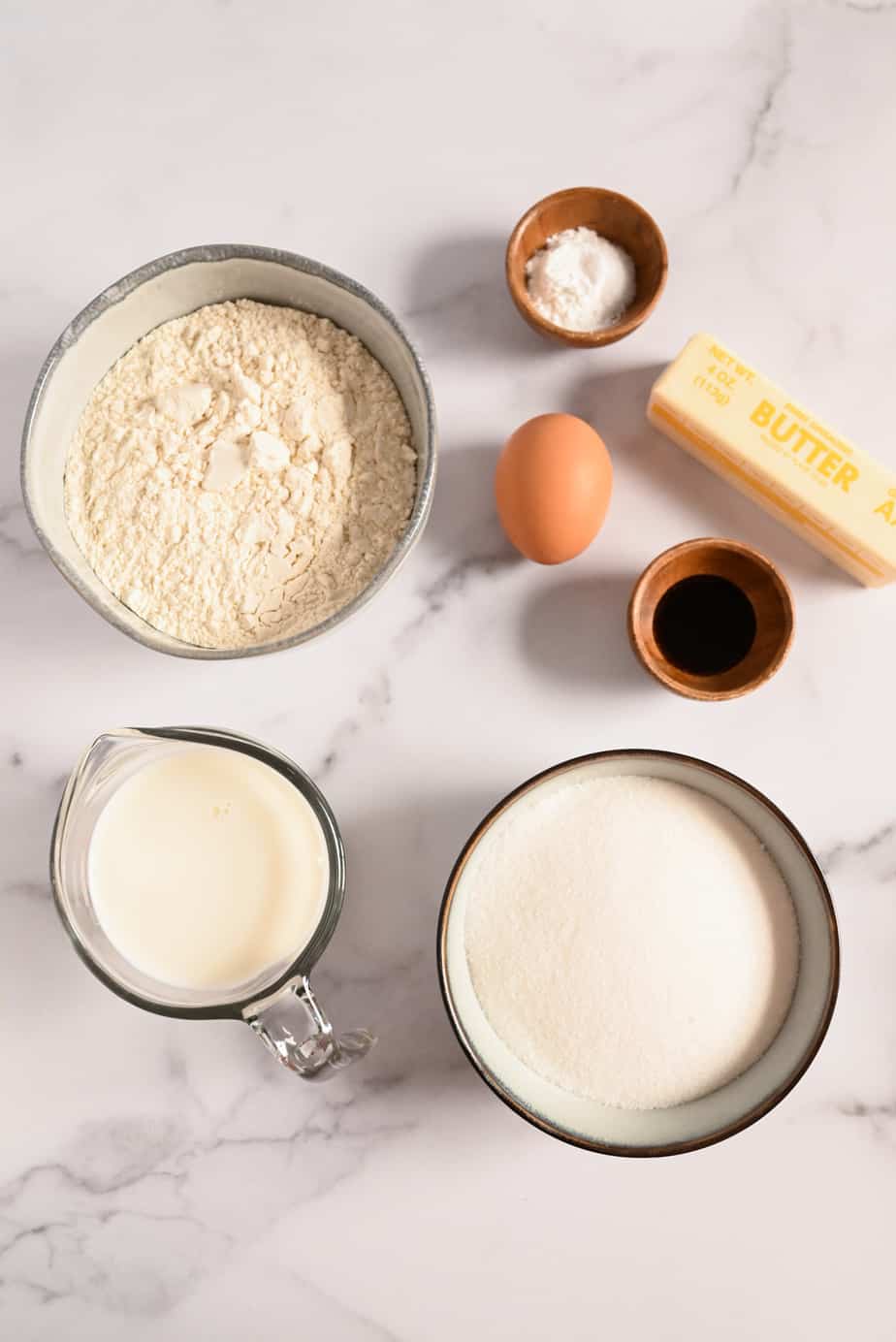 Yellow cake ingredients arranged in a marble countertop.