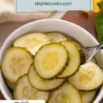 Fork lifting some slices of pickled cucumber out of a white bowl. Text overlay includes recipe name.