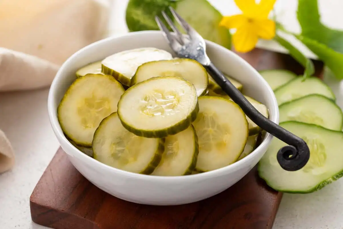 White bowl filled with pickled cucumber slices.