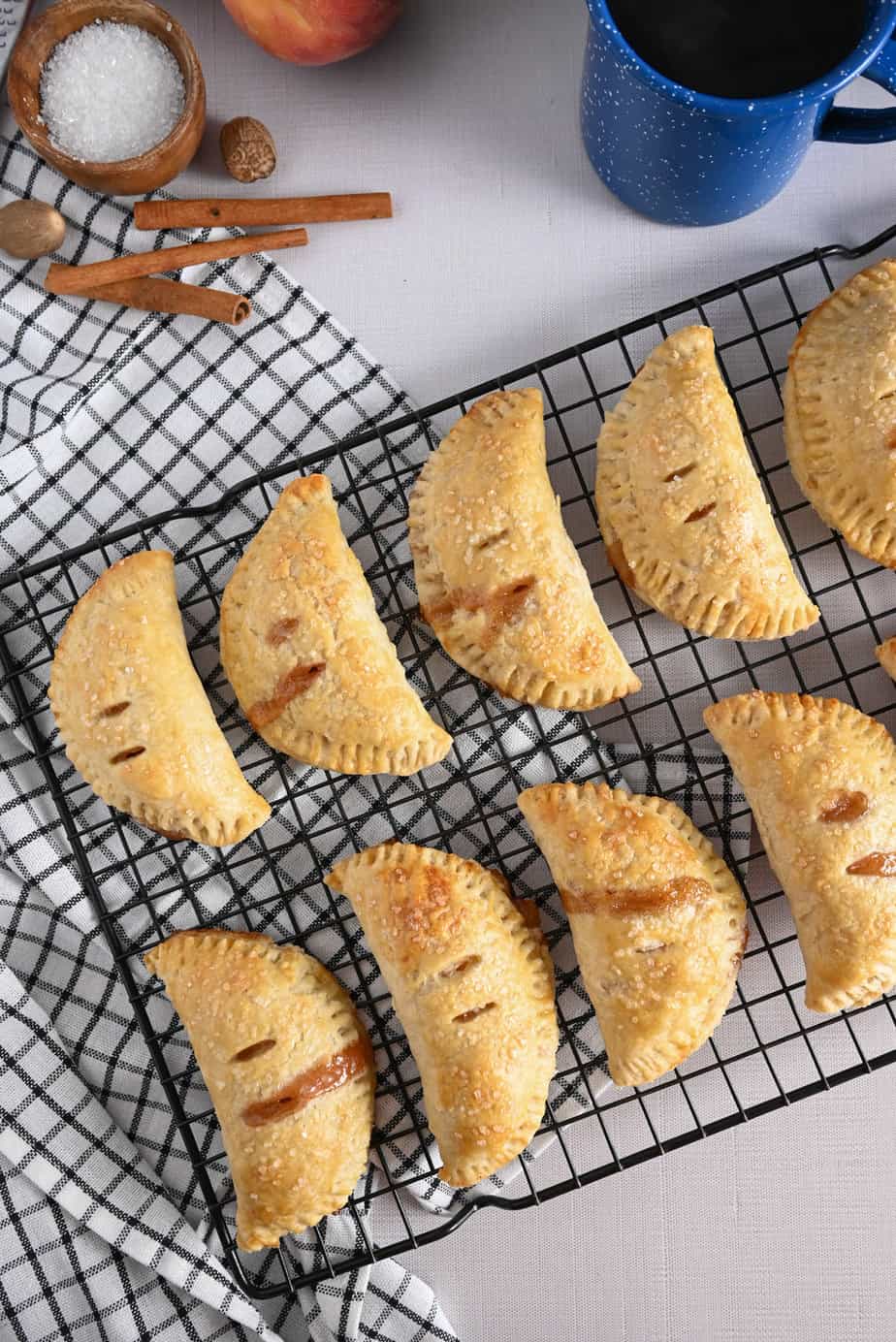 Peach hand pies cooling on a wire rack.