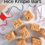 Several peanut butter rice krispie bars scattered on a marble countertop, about to be packaged up for the holidays. Text overlay includes recipe name.