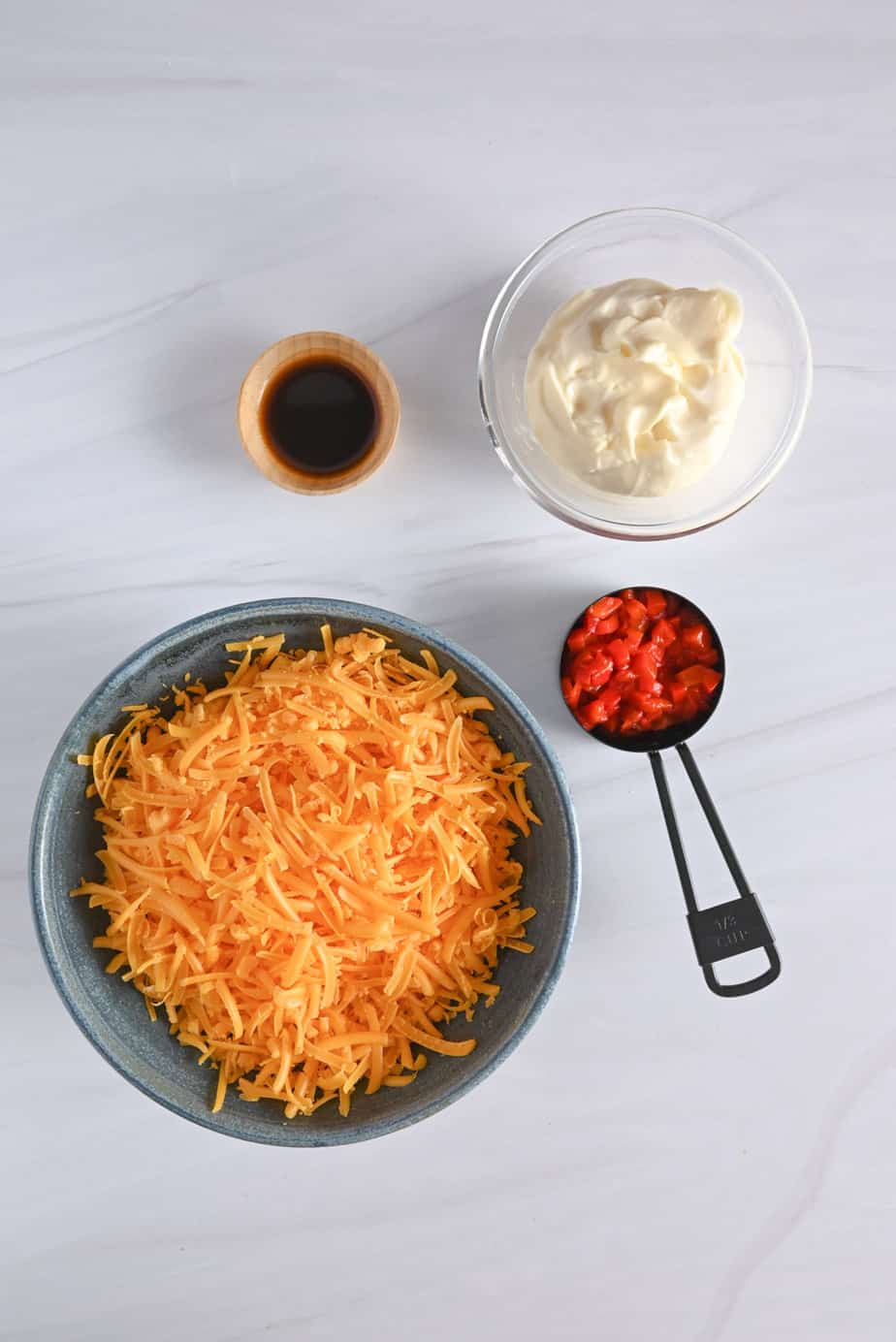 Pimento cheese ingredients on a white countertop.