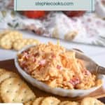 White dish filled with pimento cheese on a cutting board with butter crackers. Text overlay includes recipe name.